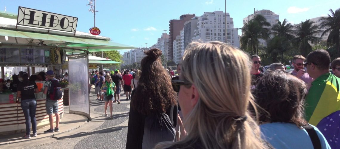 people-on-sidewalk-along-beach-in-copacabana-area-of-rio-de-janeiro-4k-SBI-350533225